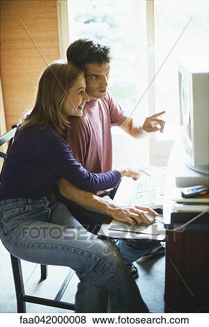 Stock Photo - Couple looking at computer together. Fotosearch