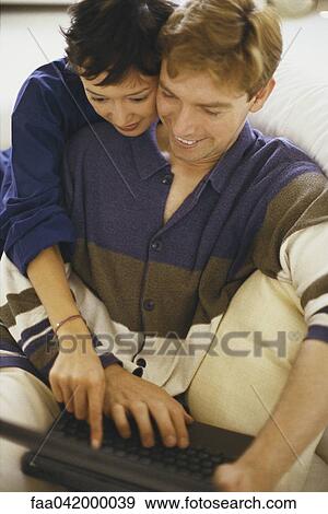 "Couple looking at laptop computer together, both smiling" View Large Photo Image Stock Photo - "Couple looking at laptop computer together, both smiling". Fotosearch