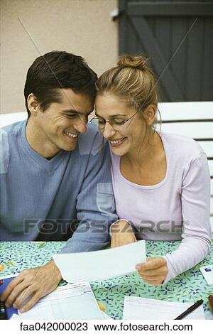 "Couple sitting at table, discussing finances, both smiling" View Large Photo Image Stock Image - "Couple sitting at table, discussing finances, both smiling". Fotosearch