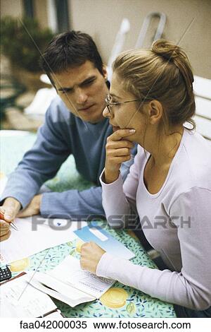 "Couple sitting at table, discussing bills" View Large Photo Image Stock Photography - "Couple sitting at table, discussing bills". Fotosearch