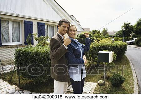 "Couple standing in front of house, making thumbs up gesture at camera" View Large Photo Image Stock Photo - "Couple standing in front of house, making thumbs up gesture at camera". Fotosearch