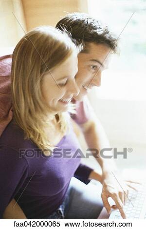 "Couple typing on keyboard together, man leaning over woman's shoulder" View Large Photo Image Stock Photography - "Couple typing on keyboard together, man leaning over woman's shoulder". Fotosearch