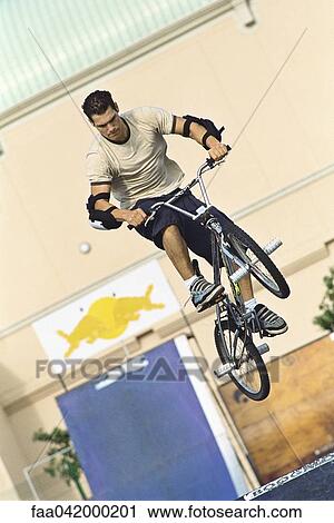 Cyclist doing midair trick at skatepark View Large Photo Image Stock Image - Cyclist doing midair trick at skatepark. Fotosearch