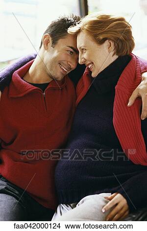 "Expecting couple embracing, smiling" View Large Photo Image Picture - "Expecting couple embracing, smiling". Fotosearch