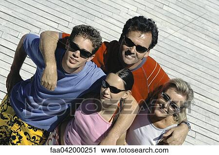 Stock Image - "Family with two children standing together smiling at camera, high angle view". Fotosearch
