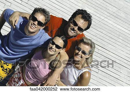 Stock Image - "Family with two children standing together smiling at camera, high angle view". Fotosearch