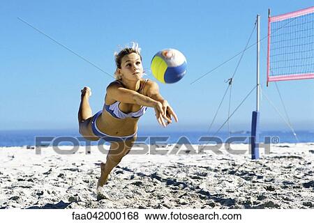 Female playing beach volleyball diving to catch ball View Large Photo Image Stock Photo - Female playing beach volleyball diving to catch ball. Fotosearch