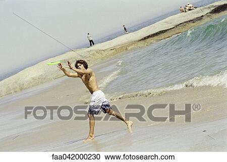 Male catching frisbee on beach View Large Photo Image Stock Image - Male catching frisbee on beach. Fotosearch