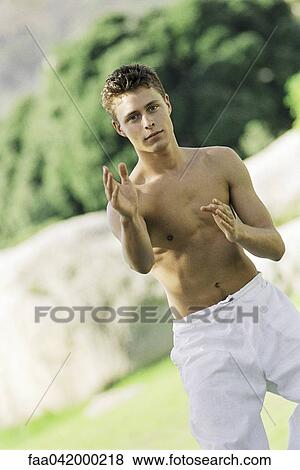 Stock Photo - "Male practicing martial arts in park setting, front view". Fotosearch