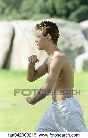 "Male practicing martial arts in park setting, side view" View Large Photo Image Stock Photo - "Male practicing martial arts in park setting, side view". Fotosearch