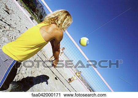 Male volleying beachball over net View Large Photo Image Stock Image - Male volleying beachball over net. Fotosearch