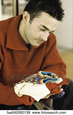 "Man looking at baby clothes, close-up" View Large Photo Image Stock Photo - "Man looking at baby clothes, close-up". Fotosearch