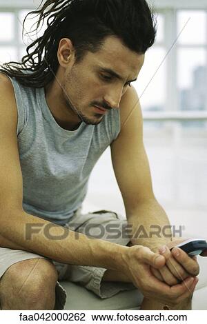 Stock Image - Man text messaging. Fotosearch
