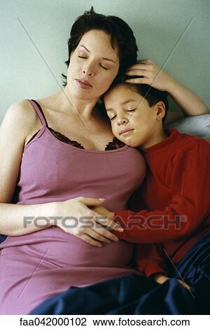 Stock Image - Pregnant woman napping with son. Fotosearch