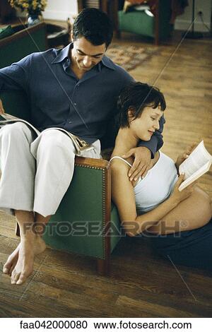 "Pregnant woman relaxing in living room with husband, both reading" View Large Photo Image Stock Image - "Pregnant woman relaxing in living room with husband, both reading". Fotosearch