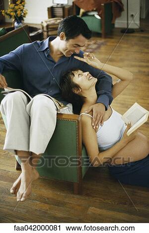 "Pregnant woman sitting on floor with book, leaning back against husband and reaching to touch his face" View Large Photo Image Stock Image - "Pregnant woman sitting on floor with book, leaning back against husband and reaching to touch his face". Fotosearch