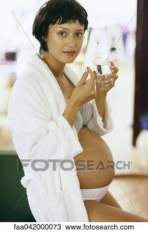 "Pregnant woman taking vitamin, looking at camera" View Large Photo Image Stock Image - "Pregnant woman taking vitamin, looking at camera". Fotosearch