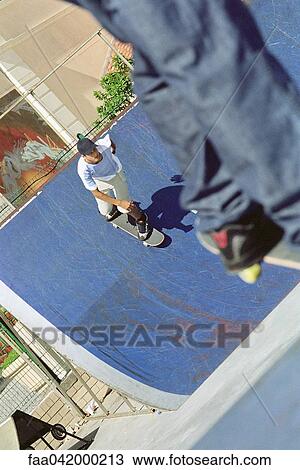 Stock Image - "Skaeboarder skating ramp, high angle view". Fotosearch