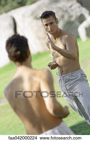 Picture - Two martial arts students spar in park setting. Fotosearch