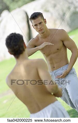 Stock Photography - Two martial arts students spar in park setting. Fotosearch