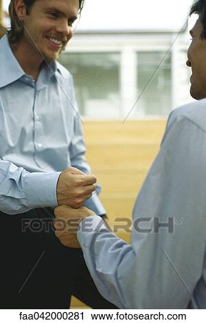 Stock Image - Two men touching fists. Fotosearch