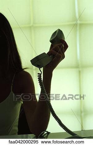 Stock Photography - "Woman holding landline phone receiver, cropped view". Fotosearch