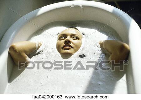 Stock Image - Woman soaking in bathtub. Fotosearch