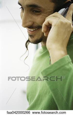 Stock Photograph - "Young man phoning, close-up". Fotosearch