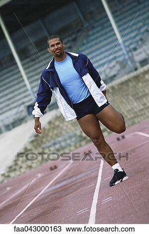 Athlete doing stretches on track View Large Photo Image Stock Image - Athlete doing stretches on track. Fotosearch