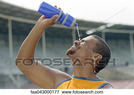 Stock Photo - Athletic man pouring water on face. Fotosearch