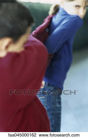 Boy covering his eyes crying, girl in background looking over shoulder watching View Large Photo Image Stock Image - Boy covering his eyes crying, girl in background looking over shoulder watching. Fotosearch