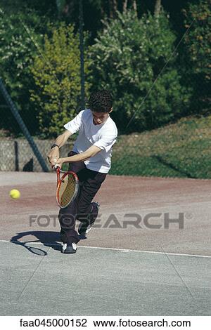 Stock Image - Boy playing tennis. Fotosearch
