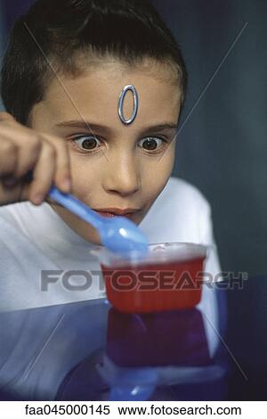 Boy with wide eyed expression eating jelly dessert View Large Photo Image Stock Photography - Boy with wide eyed expression eating jelly dessert. Fotosearch