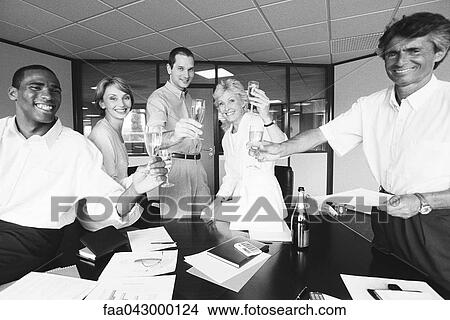 Business associates celebrating with champagne in office View Large Photo Image Picture - Business associates celebrating with champagne in office. Fotosearch