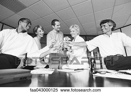 Business associates clinking glasses, celebrating with champagne in office View Large Photo Image Stock Photography - Business associates clinking glasses, celebrating with champagne in office. Fotosearch