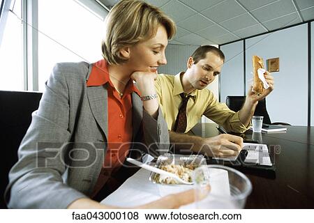 Business associates discussing calendar event over casual lunch in conference room View Large Photo Image Stock Photo - Business associates discussing calendar event over casual lunch in conference room. Fotosearch