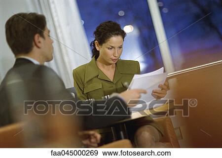 Stock Photo - Business associates discussing contract at table. Fotosearch