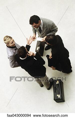 Picture - Business associates standing together having discussion, high angle view. Fotosearch