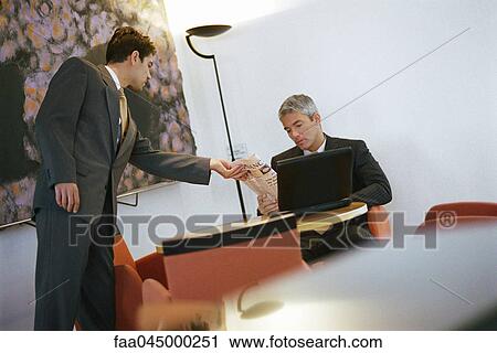 Businessman showing colleague financial section of newspaper View Large Photo Image Stock Image - Businessman showing colleague financial section of newspaper. Fotosearch