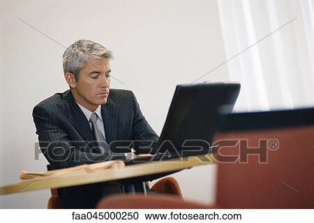 Stock Image - Businessman working on laptop computer. Fotosearch