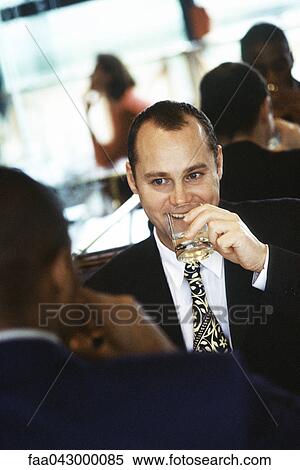 Stock Photography - Businessmen having drink together in restaurant. Fotosearch