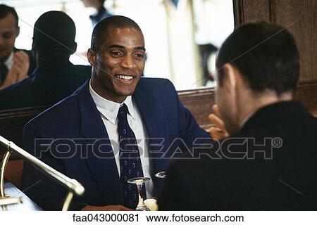Stock Image - Businessmen together in restaurant. Fotosearch
