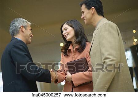 Businesswoman shaking hands with male colleague View Large Photo Image Stock Photo - Businesswoman shaking hands with male colleague. Fotosearch
