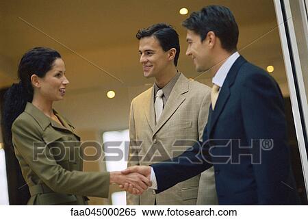 Businesswoman shaking male associate's hand View Large Photo Image Stock Photography - Businesswoman shaking male associate's hand. Fotosearch