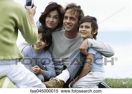 Stock Photography - Child taking picture of family. Fotosearch