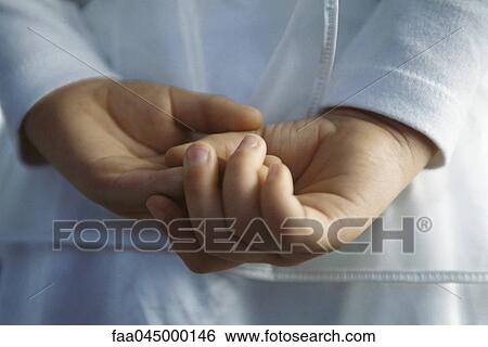 Stock Photograph - Child with hands clasped behind back, close-up. Fotosearch