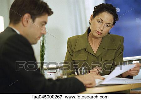 Stock Photo - Executives reviewing document together. Fotosearch