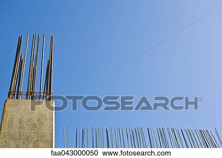 Exposed rebar protruding from unfinished concrete column against blue sky, low angle view View Large Photo Image Stock Image - Exposed rebar protruding from unfinished concrete column against blue sky, low angle view. Fotosearch