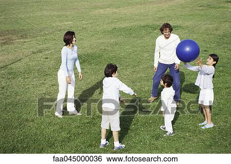 Family playing with ball in grassy field View Large Photo Image Stock Photograph - Family playing with ball in grassy field. Fotosearch