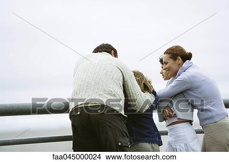 Picture - Family together at seaside, parents embracing children. Fotosearch